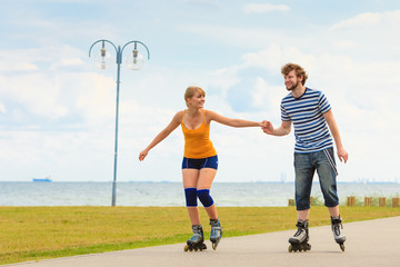 Young couple on roller skates riding outdoors