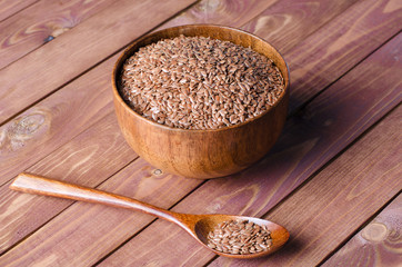 flax seeds in wooden bowl on rustic background