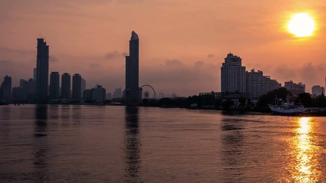 Timelapse - Bangkok city at sunset with lighted at The downtown area with the Chao Phraya River.