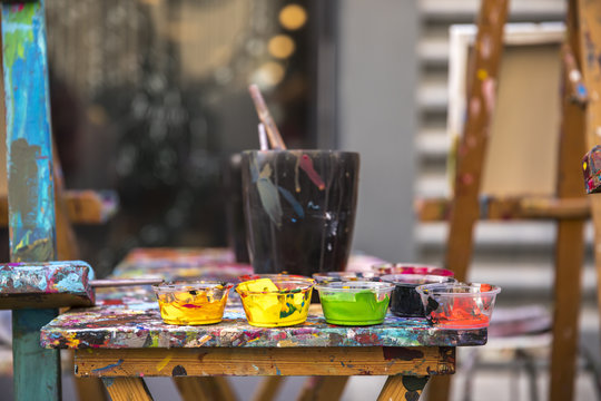 paint and brushes on a clorful table