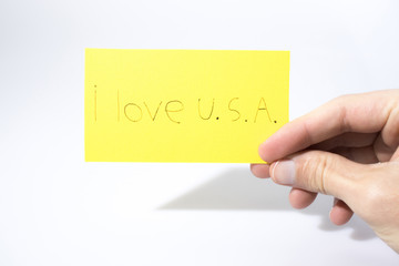 I love U.S.A. handwrite with a hand on a yellow paper