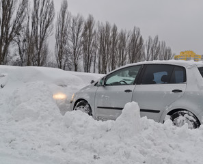 Fototapeta na wymiar Car get stuck in snow at open parking lot after heavy snowstorm