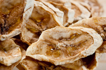 Sliced ripe dried banana cut with mugs on a wooden background