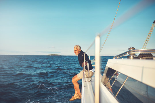 Mature man admiring the sea view from his sailboat