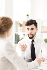 Young businessman talking with his female colleague at office