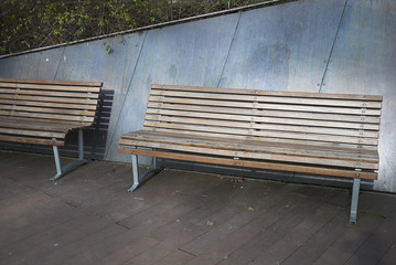 Fototapeta na wymiar Milan, Italy - March 09, 2018: Wood park bench in Porta Nuova