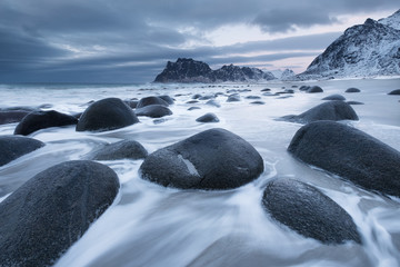 Fototapeta na wymiar Seashore with stones during sunset. Beautiful natural seascape in the Norway