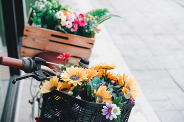 Vintage Bicycle with flowers on summer standing on the street.Bicycle with basket full of flowers.
