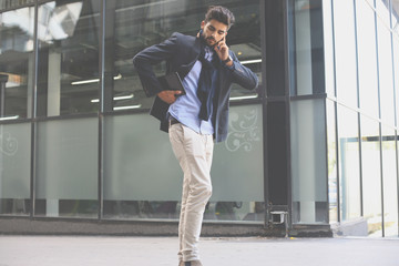 Businessman on city street holding digital tablet.