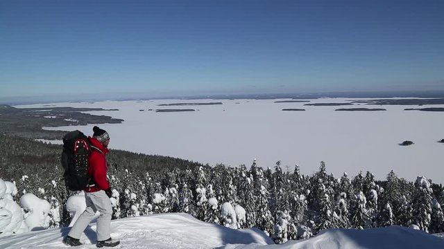 Snowshoe hiker on Koli peak enjoys the winter landscape