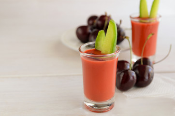 Cherry gazpacho served in glass shot, this Spanish raw soup is very refreshing and perfect for hot summer. Healthy food and raw food ideas. Copy space