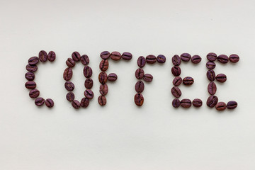 Word coffee made of roasted black coffee beans on white background. Coffee symbol and decoration. Morning drink concept. Coffee ingredient and art. 