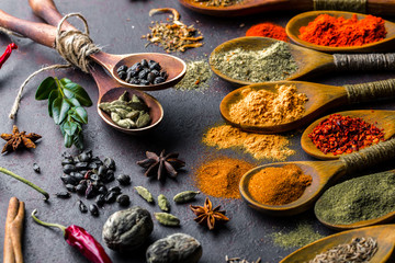Fototapeta na wymiar Spices for cooking with kitchen accessories on an old background