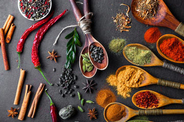 Spices for cooking with kitchen accessories on an old background
