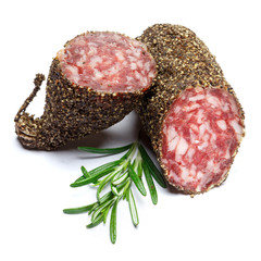 Dried organic salami sausage covered with pepper on white background