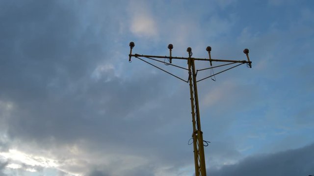 Airplane passing and arriving to airport above a lamp posts