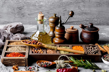 Spices for cooking with kitchen accessories on an old background