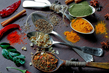 Spices for cooking with kitchen accessories on an old background