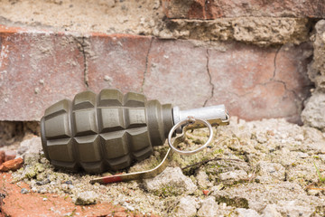 Hand grenade lying on a brick wall