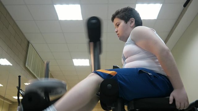 fat kid boy training muscles of legs fat burning. children concept overweight sport and health