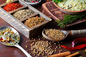 Spices for cooking with kitchen accessories on an old background