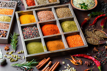 Spices for cooking with kitchen accessories on an old background
