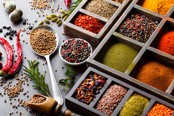 Spices for cooking with kitchen accessories on an old background
