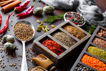 Spices for cooking with kitchen accessories on an old background