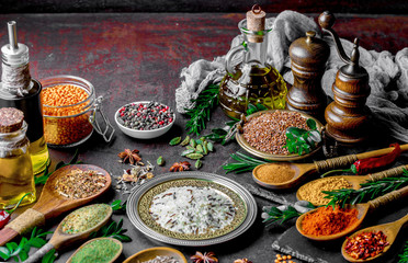 Spices for cooking with kitchen accessories on an old background