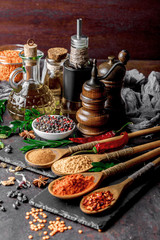 Naklejka na ściany i meble Spices for cooking with kitchen accessories on an old background
