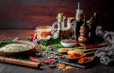 Spices for cooking with kitchen accessories on an old background