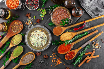 Spices for cooking with kitchen accessories on an old background