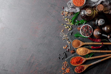Spices for cooking with kitchen accessories on an old background