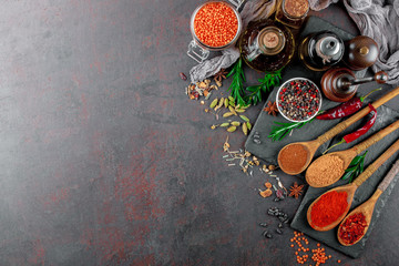 Spices for cooking with kitchen accessories on an old background
