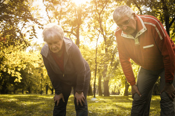 Tired senior couple resting after exercising.