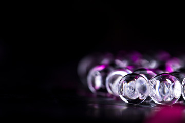 Violet and dark water gel balls. Macro photo, can be used both for advertising or cosmetics and for medicine. Abstract background.