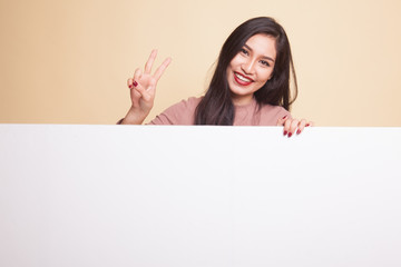 Fototapeta premium Young Asian woman point to a blank sign.