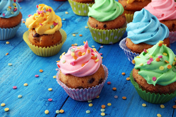Tasty cupcakes on wooden background. Birthday cupcake in rainbow colors