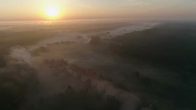 Sunrise Drone footage above the fog curvy river and woods