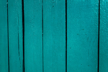 Detail of parallel vertical wooden boards painted in green