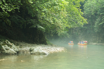 Tourists sail on a rubber boat along the canyon. Georgia
