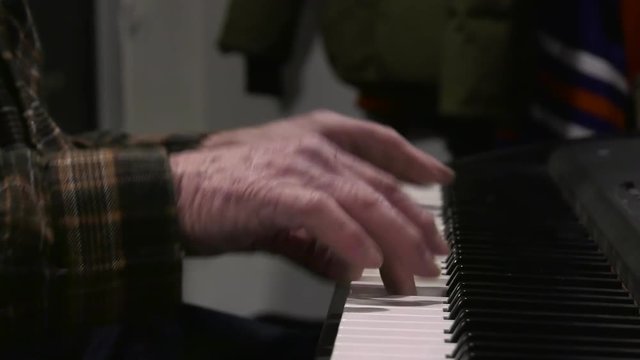 old man hands playing piano