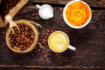 Espresso mit Herz, Milchkännchen, frisch geröstete Kaffeebohnen und Blüte