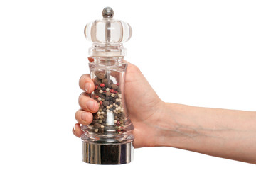hand holding glass pepper mill isolated on white background