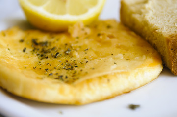 Saganaki - a Greek dish of kefalograviera, kasseri, kefalotyri, or feta cheese, pan seared and served with lemon and bread