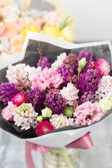 Bouquet of Beautiful violet and pink hyacinths. Spring flowers in vase on gray table background. bulbous plant
