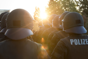 Polizisten von hinten bei Gegenlicht