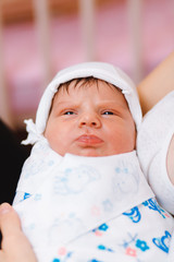 New born baby resting in mothers arms.