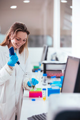 young woman scientist working with a pipette in a laboratory
