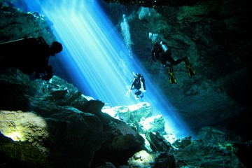 Beautiful beams of light in a Cave and Cavern during a Scuba Diving exploration of a sinkhole or Cenote in the riviera Maya, Mexico